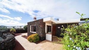 a small house with a stone wall at Casa Margarita 3 in Mala