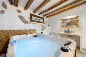 a large white bath tub in a room with wooden ceilings at El racó de les escales in Tivissa +18 photos