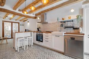 a large kitchen with white cabinets and appliances at El racó de les escales in Tivissa