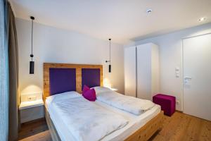 a bedroom with a bed with white sheets and pink pillows at Stoana Apt 2-2 in San Giacomo