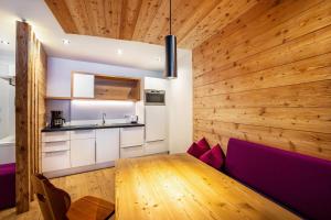 a kitchen and dining room with a wooden wall at Stoana Apt 2-2 in San Giacomo