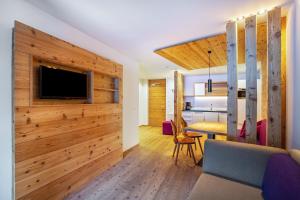 a living room with a wooden wall and a tv at Stoana Apt 2-2 in San Giacomo
