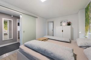 a bedroom with two beds and a mirror at Haus Birkenösch in Aach-Linz
