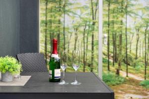 a bottle of wine and two wine glasses on a table at Haus Birkenösch in Aach-Linz