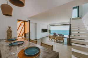 a dining room with a table and a view of the ocean at River Villas Plomari - Luxury Villas with Direct Pool Access in Plomari