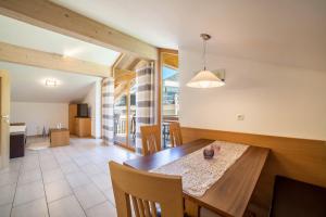 a kitchen and dining room with a table and chairs at Ferienwohnung Edelweiss in Pfelders