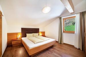 a bedroom with a large bed and a window at Ferienwohnung Edelweiss in Pfelders