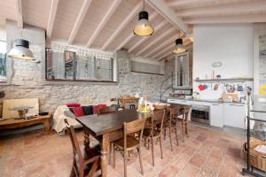 a kitchen and dining room with a wooden table and chairs at Loft e Veranda sul Lago di Como in Blevio +34 photos