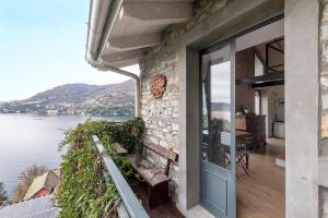 a house with a balcony with a view of the water at Loft e Veranda sul Lago di Como in Blevio