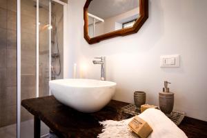 a bathroom with a white bowl sink on a wooden counter at Loft e Veranda sul Lago di Como in Blevio