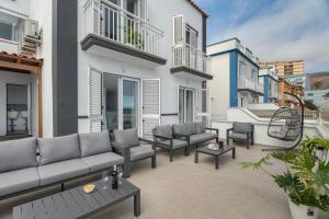 a patio with couches and chairs on a building at Villa Atlantico in Candelaria