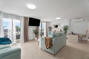 a living room with a blue couch and a tv at Villa Atlantico in Candelaria