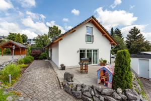 a white house with a brick patio at Haus Schönblick in Willingen