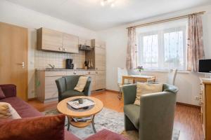 a living room with a couch and chairs and a table at Ilse - Ferienwohnungen Zinnowitz in Zinnowitz
