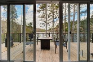 a balcony with a table and chairs on a deck at Luft Skift Spa - Waterfront & Private Spa in Lac-aux-Sables