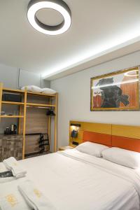 a bedroom with a large white bed with a light at Hotel Erika in Alexandroupoli +82 photos
