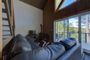 a large leather couch in a living room with a window at Luft Skift Spa - Waterfront & Private Spa in Lac-aux-Sables