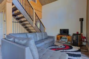 a living room with a blue couch and a staircase at Luft Skift Spa - Waterfront & Private Spa in Lac-aux-Sables