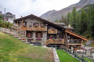 a house with wooden balconies on a mountain at Lo Pailler de Mamma e Pappa in Valsavarenche