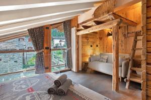 a bedroom in a log cabin with a bed and a couch at Lo Pailler de Mamma e Pappa in Valsavarenche