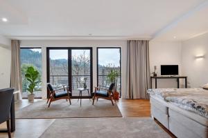 a bedroom with a bed and chairs and a television at Sonnige Ferienwohnung im Kinzigtal in Wolfach