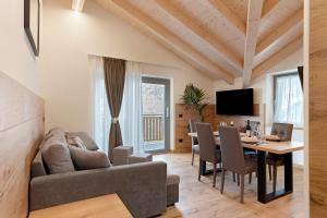 a living room and dining room with a table and a couch at Alpen Blumen in San Lorenzo in Banale