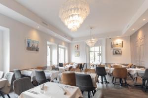 a dining room with tables and chairs and a chandelier at Villa chardonnay in Pradons