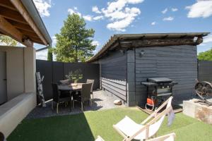 a backyard with a table and chairs and a grill at Villa chardonnay in Pradons