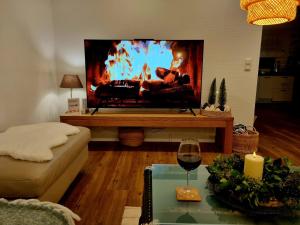 a living room with a tv and a glass of wine at Second Home in Birlenbach