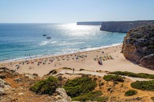 a group of people on a beach near the ocean at Casa Vitorino in Sagres