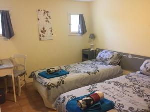 a bedroom with two beds and a table and a chair at Gite La Lède in Bias +9 photos