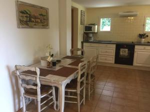 a kitchen with a table and chairs in a kitchen at Gite La Lède in Bias