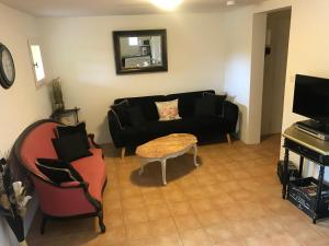 a living room with a black couch and a table at Gite La Lède in Bias