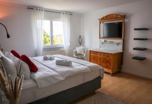 a bedroom with a bed and a dresser and a television at Second Home in Birlenbach
