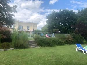 a yard with two lawn chairs and a house at Gite La Lède in Bias