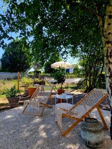 two chairs and a table under a tree at Second Home in Birlenbach