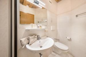 a white bathroom with a sink and a toilet at Eichernhof Apartment Apfelblüte in Verano +19 photos