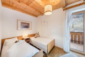 two beds in a room with a window at Eichernhof Apartment Apfelblüte in Verano