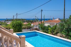a swimming pool on the balcony of a house at Villa Petre in Cala en Porter