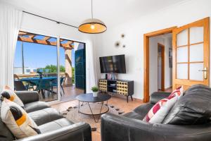 a living room with two couches and a table at Villa Petre in Cala en Porter