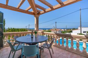 a table and chairs on a balcony with a view of the ocean at Villa Petre in Cala en Porter