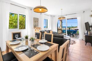 a dining room with a table and a couch at Villa Petre in Cala en Porter