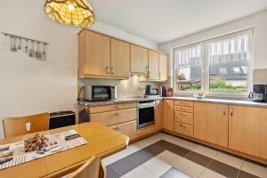 a kitchen with wooden cabinets and a table at 2 Zimmer Ferienwohnung 69 Qm in Mittenwalde