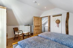 a bedroom with a bed and a chair at Ferienhaus Glücksschmiede in Schmallenberg