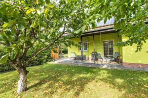 a yellow house with a tree in the yard at 2 Zimmer Ferienwohnung 69 Qm in Mittenwalde