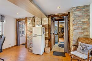a kitchen with a refrigerator and a brick wall at Ferienhaus Glücksschmiede in Schmallenberg