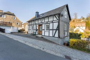 a black and white building on a street at Ferienhaus Glücksschmiede in Schmallenberg