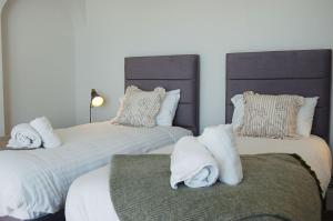 a bedroom with two beds with towels on them at Morwendon House with Sea View in Llanaber