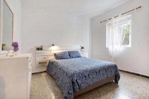 a white bedroom with a bed and a window at Brisa marina in Morro del Jable