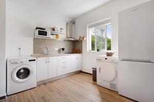 a white kitchen with a sink and a washing machine at Brisa marina in Morro del Jable +12 photos